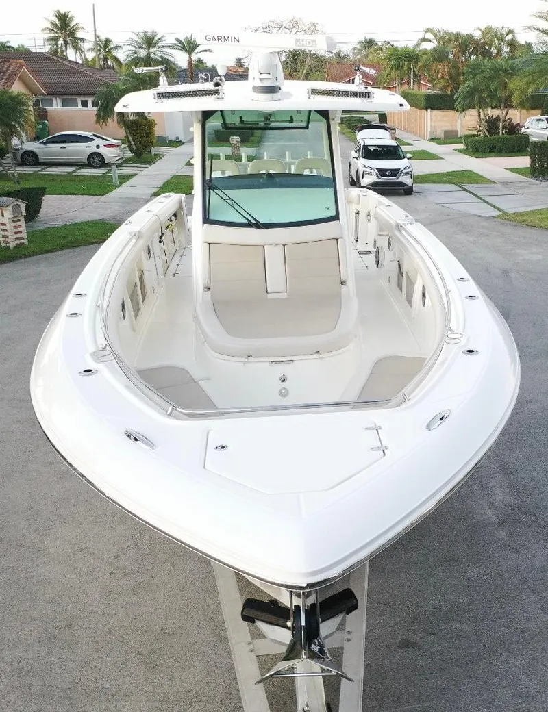 Slide: The Image of 2021 Boston Whaler 350 Outrage boat, front view, parked in a residential area. - 14