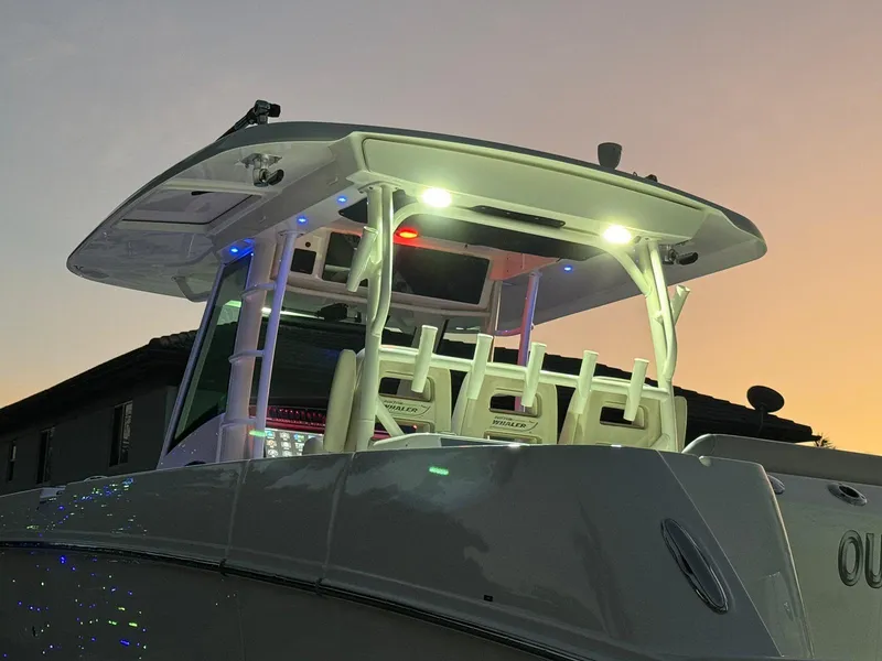 Slide: The Image of 2021 Boston Whaler 350 Outrage boat at sunset with illuminated deck lights. - 16