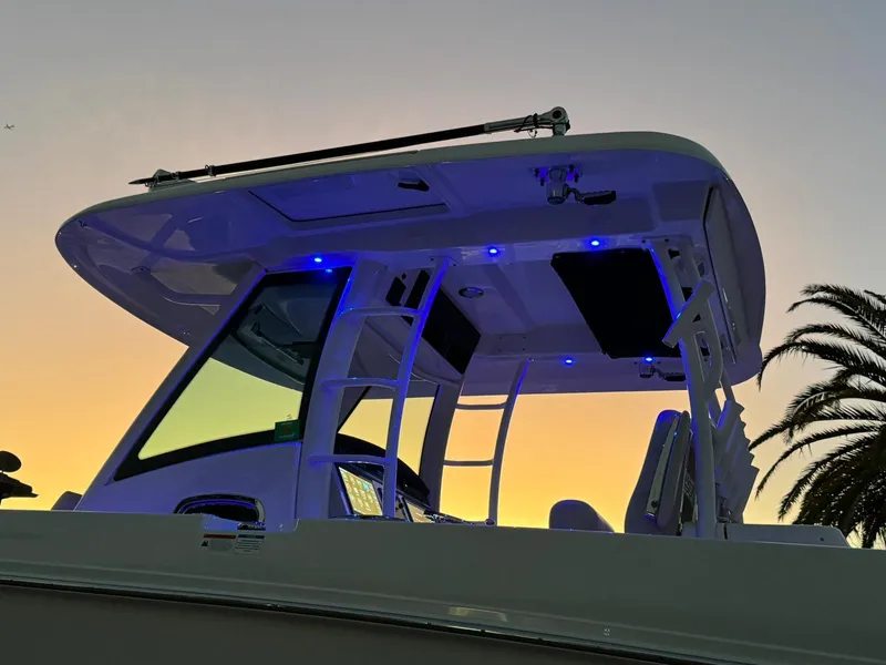 Slide: The Image of 2021 Boston Whaler 350 Outrage boat at sunset with blue LED lights. - 18