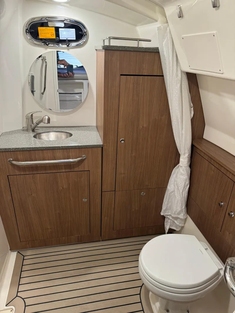 Slide: The Image of 2021 Boston Whaler 350 Outrage boat bathroom with wooden cabinetry and modern fixtures. - 34