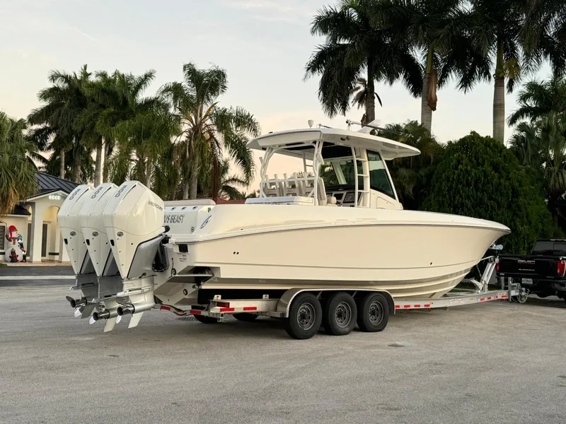 Slide: The Image of 2021 Boston Whaler 350 Outrage boat on a trailer with triple outboard engines. - 8