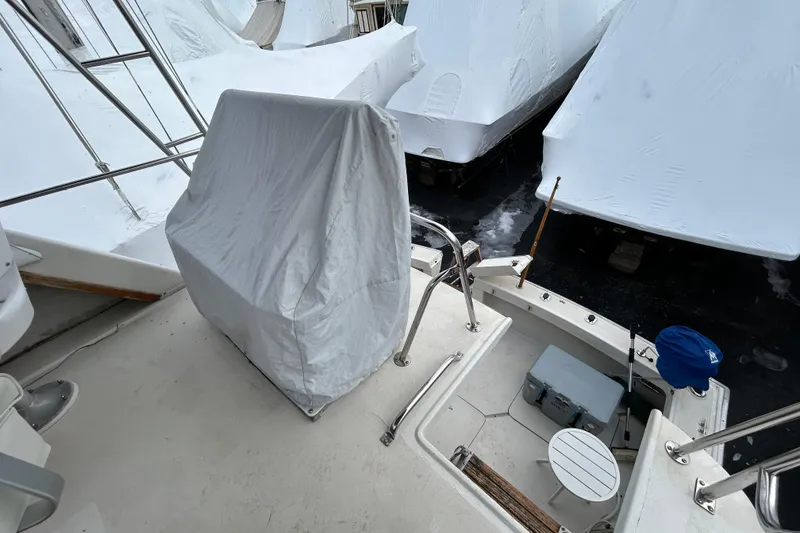 Slide: The Image of 1983 Silverton 34 Convertible boat deck with covered seating and winterized surroundings. - 12