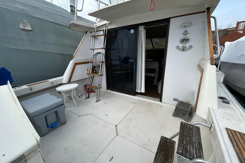 Slide: The Image of 1983 Silverton 34 Convertible boat deck with seating, ladder, and sliding door. - 15