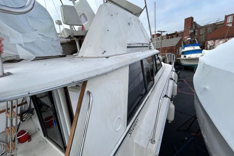 Slide: The Image of 1983 Silverton 34 Convertible boat docked, showcasing its classic design and structure. - 17