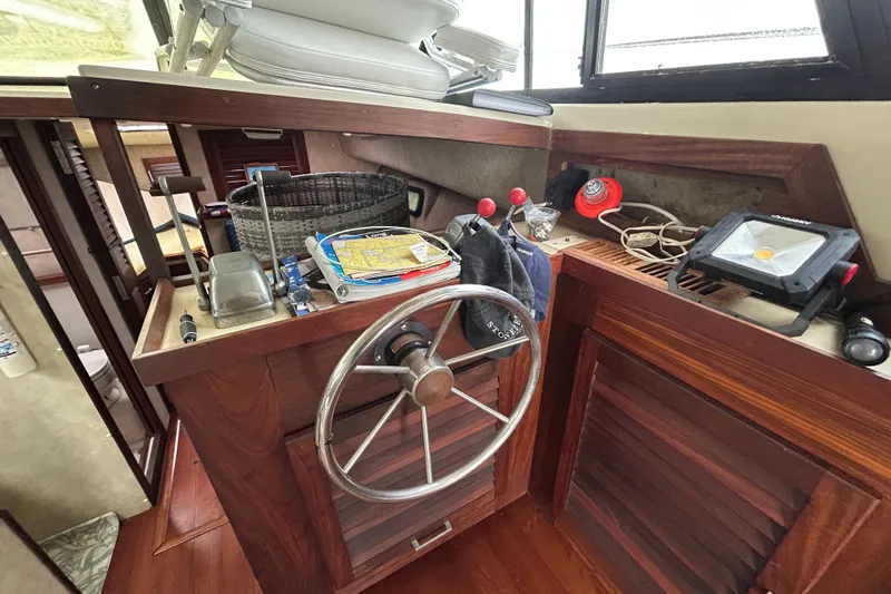 Slide: The Image of 1983 Silverton 34 Convertible boat helm with steering wheel and navigation tools. - 26