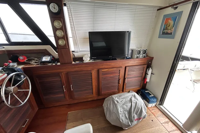 Slide: The Image of Interior of 1983 Silverton 34 Convertible boat with wooden cabinets and nautical instruments. - 28