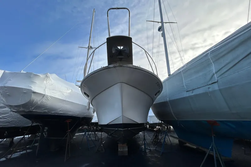 Slide: The Image of 1983 Silverton 34 Convertible boat in dry dock, surrounded by covered vessels. - 3