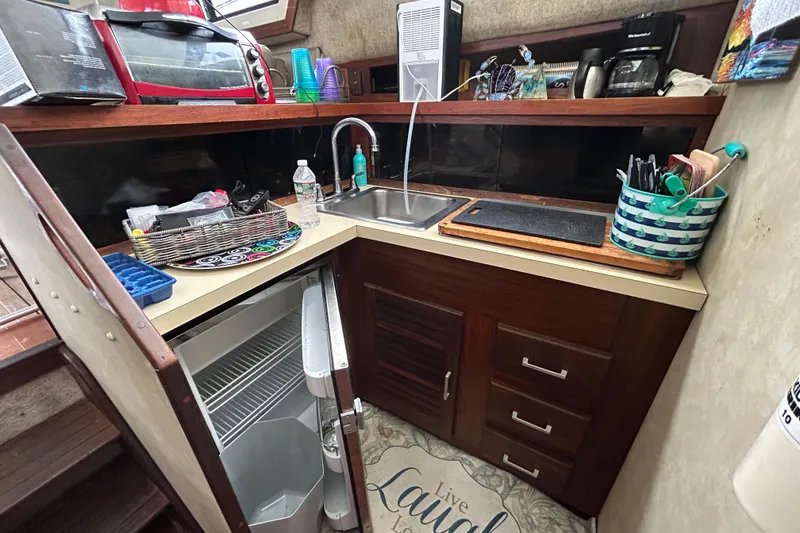 Slide: The Image of 1983 Silverton 34 Convertible kitchen with sink, mini fridge, and countertop appliances. - 31