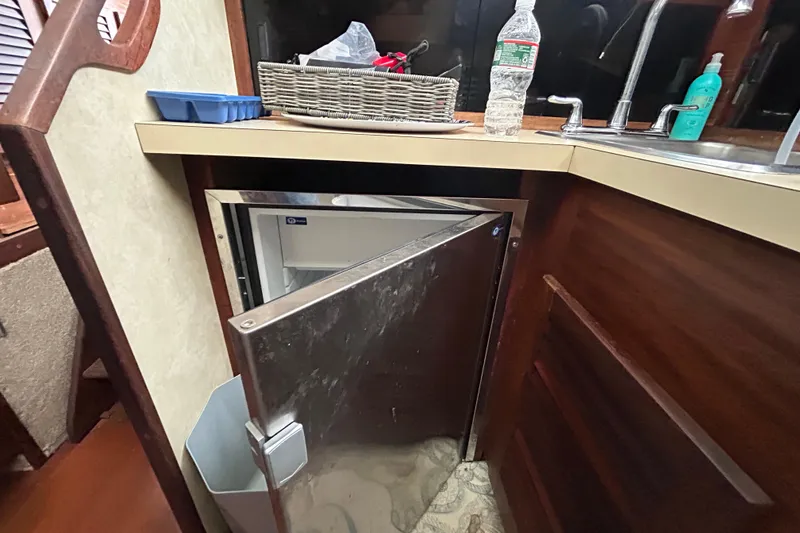 Slide: The Image of 1983 Silverton 34 Convertible kitchen with open fridge, sink, and countertop items. - 33