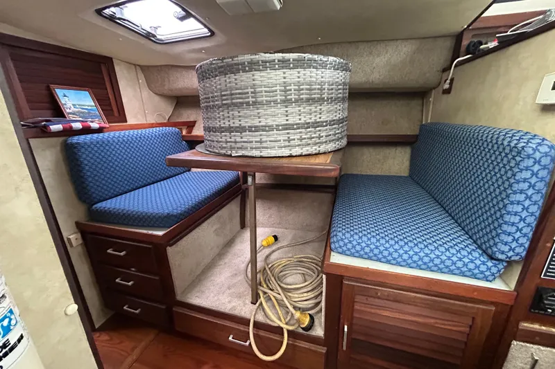 Slide: The Image of 1983 Silverton 34 Convertible interior with blue seating, wooden accents, and nautical decor. - 35