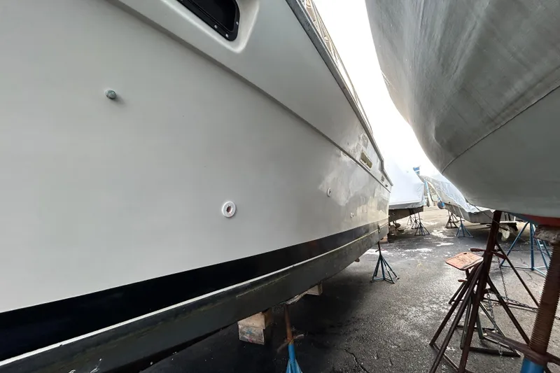 Slide: The Image of 1983 Silverton 34 Convertible boat on stands in a marina, side view. - 4