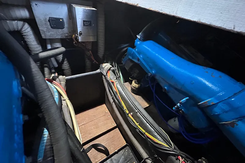 Slide: The Image of Engine room of 1983 Silverton 34 Convertible with visible wiring and blue engine components. - 43