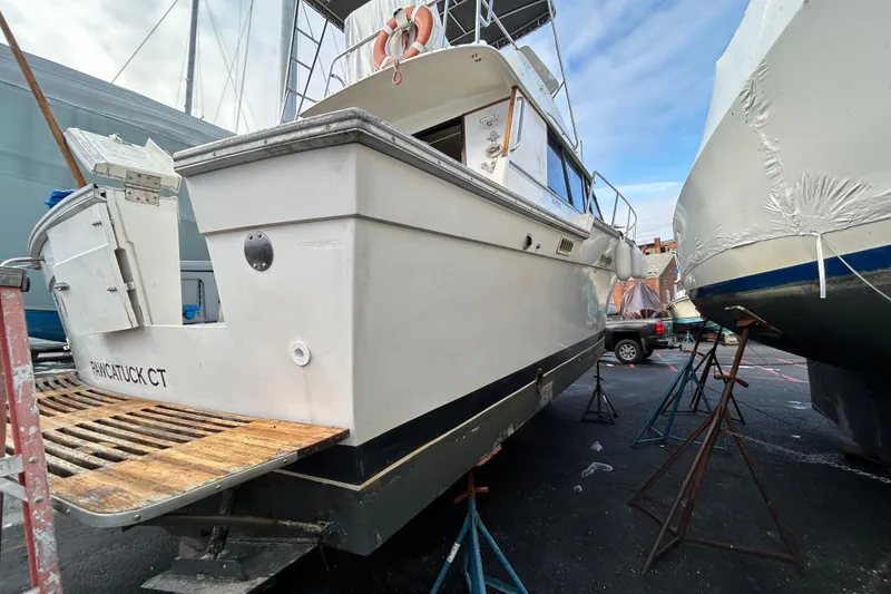 Slide: The Image of 1983 Silverton 34 Convertible boat on dry dock, PANCATUCK CT, with clear sky background. - 6