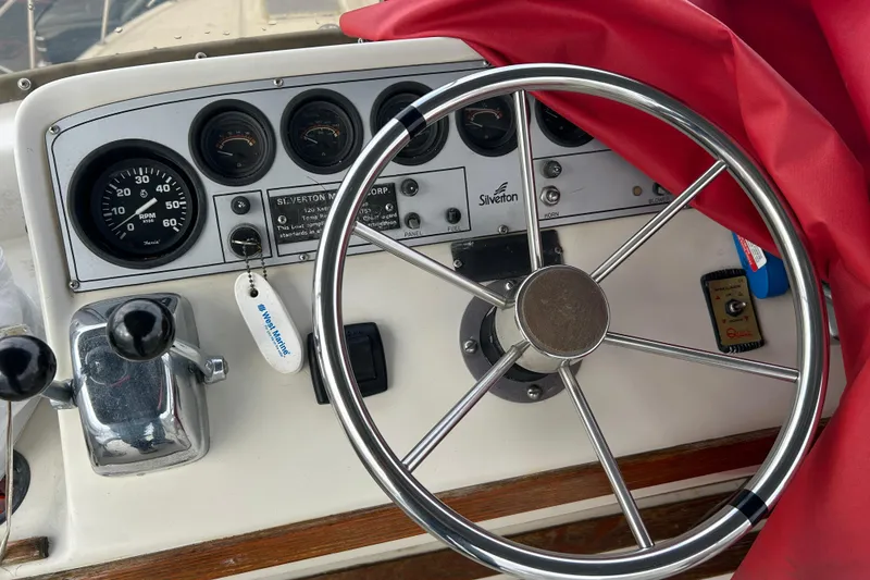 Slide: The Image of 1983 Silverton 34 Convertible boat dashboard with steering wheel and gauges. - 8