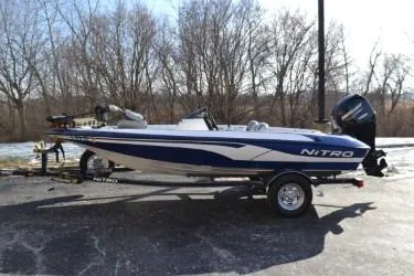 The Image of 2008 Nitro 640 boat on trailer, parked outdoors with trees in the background. - 1