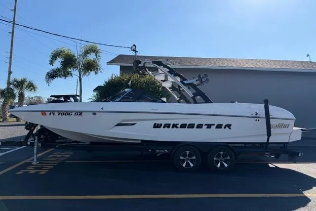 The Image of 2013 Malibu Wakesetter 24 MXZ boat on trailer, parked outdoors. - 1
