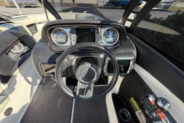 Slide: The Image of 2013 Malibu Wakesetter 24 MXZ dashboard with steering wheel and control panel. - 10
