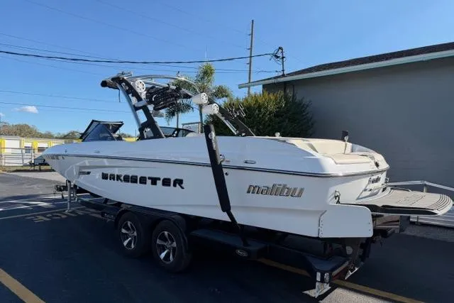 Slide: The Image of 2013 Malibu Wakesetter 24 MXZ boat on trailer, parked outdoors. - 5