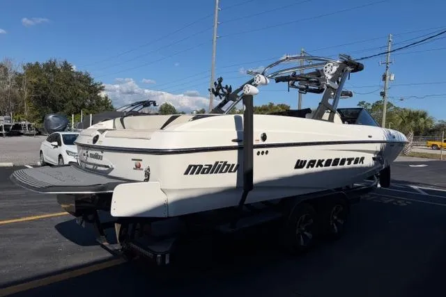 Slide: The Image of 2013 Malibu Wakesetter 24 MXZ boat on trailer, parked outdoors. - 6
