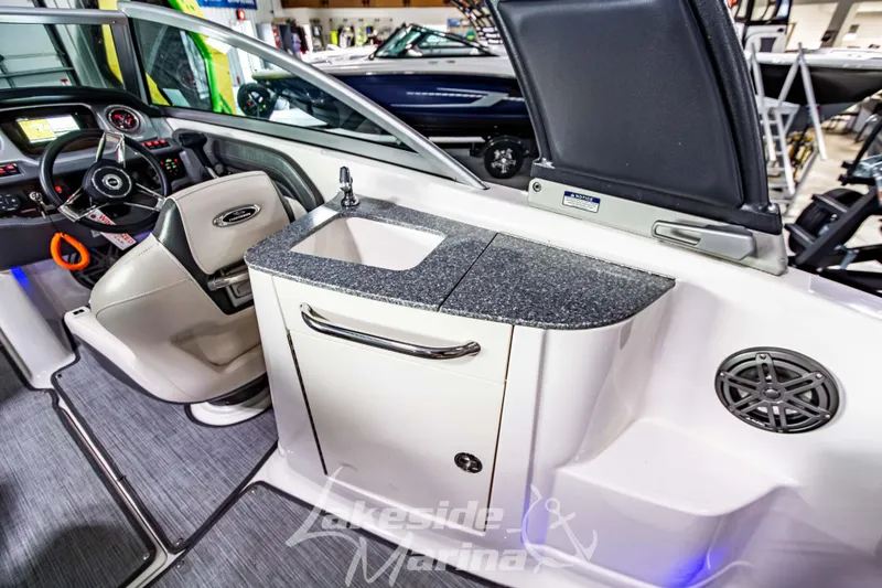 Slide: The Image of 2017 Chaparral 244 Sunesta boat interior with steering wheel and sink area. - 16
