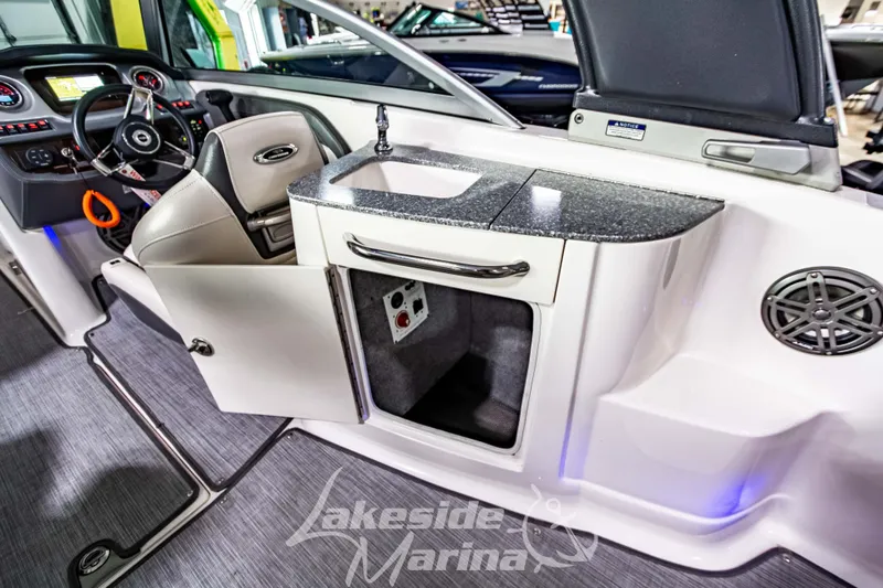 Slide: The Image of Interior of 2017 Chaparral 244 Sunesta boat with open cabinet and steering area. - 18