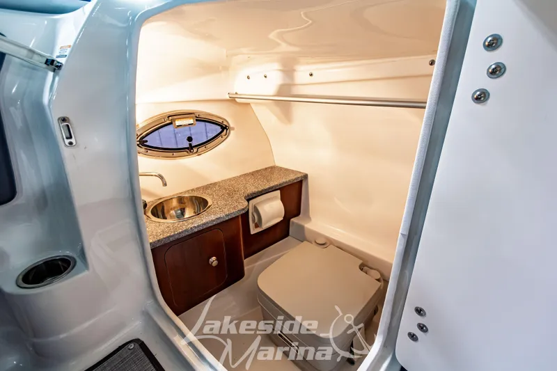 Slide: The Image of 2017 Chaparral 244 Sunesta boat interior with sink, toilet, and porthole window. - 29