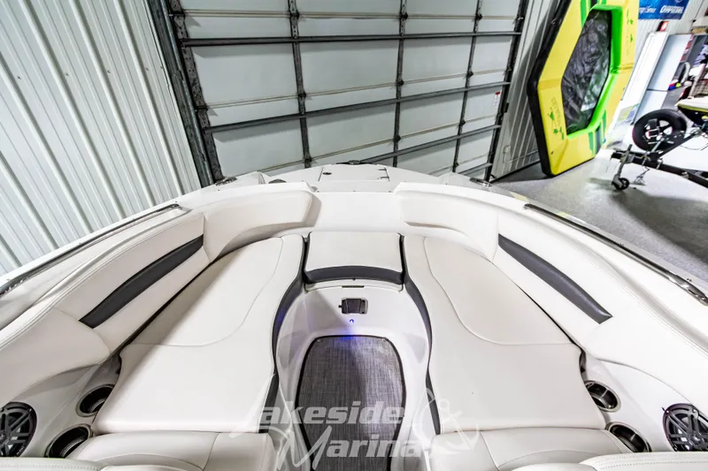 Slide: The Image of 2017 Chaparral 244 Sunesta boat interior with white seating in a garage setting. - 35