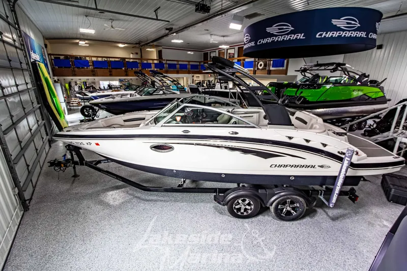 Slide: The Image of 2017 Chaparral 244 Sunesta boat displayed in a showroom with other boats. - 8