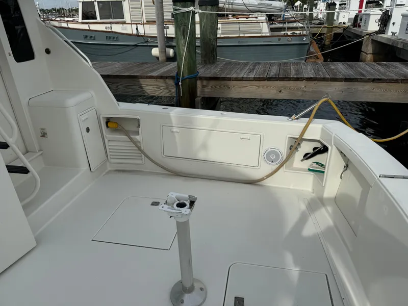 Slide: The Image of 1997 Ocean Yachts 40 Super Sport boat deck at marina, showing storage compartments and utility connections. - 13