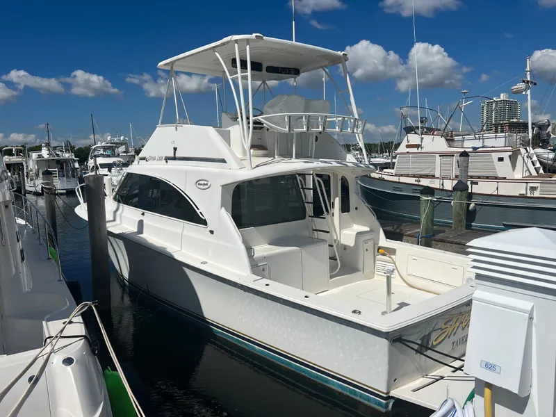 Slide: The Image of 1997 Ocean Yachts 40 Super Sport docked at a marina under a clear blue sky. - 14