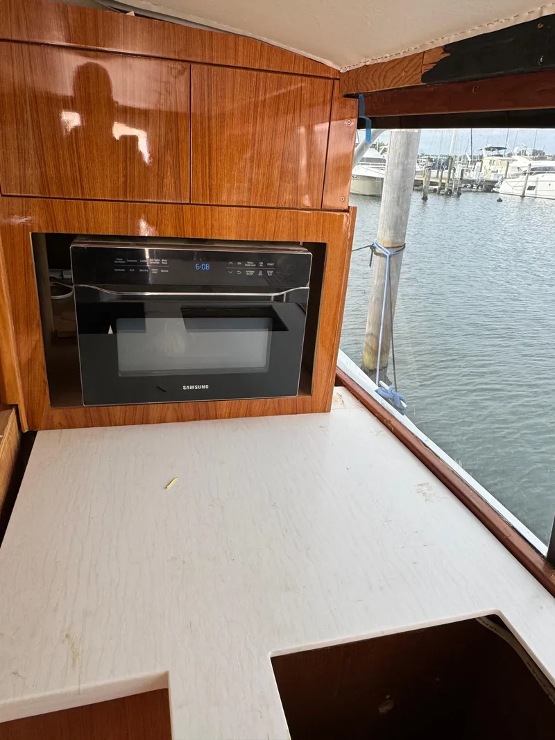 Slide: The Image of 1997 Ocean Yachts 40 Super Sport kitchen area with microwave and marina view. - 29
