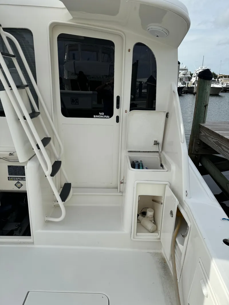 Slide: The Image of 1997 Ocean Yachts 40 Super Sport boat deck with storage compartments and dock view. - 4