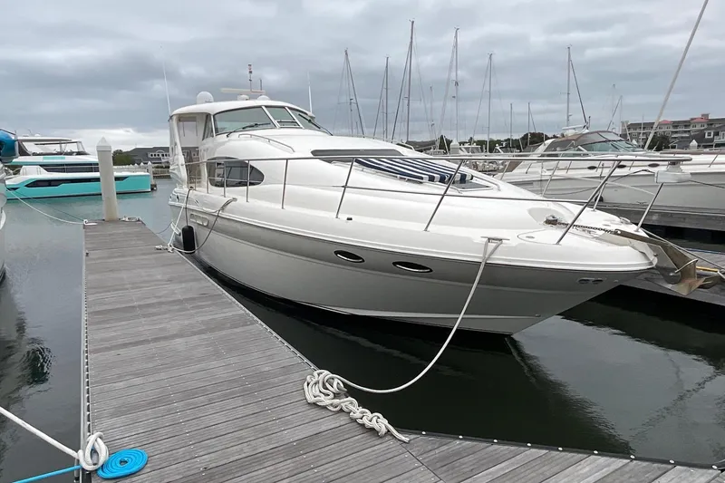 The Image of 2002 Sea Ray 480 Motor Yacht docked at marina under cloudy skies. - 0