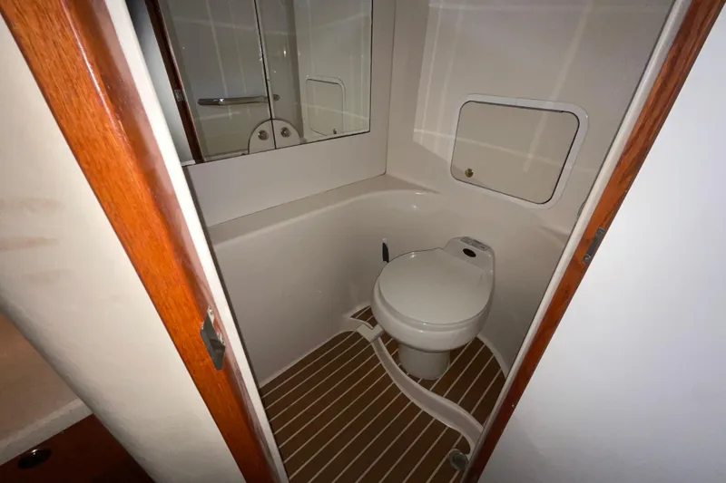 Slide: The Image of 2002 Sea Ray 480 Motor Yacht bathroom with toilet and wooden flooring. - 31
