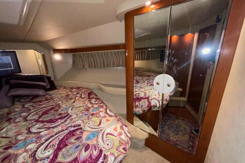 Slide: The Image of Luxurious 2002 Sea Ray 480 Motor Yacht bedroom with mirrored closet and vibrant bedding. - 38