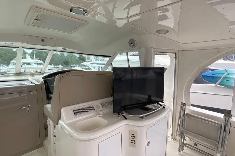 Slide: The Image of 2002 Sea Ray 480 Motor Yacht interior with helm, TV, and seating area. - 4