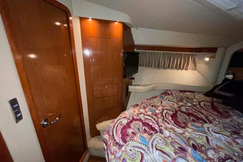 Slide: The Image of Luxurious 2002 Sea Ray 480 Motor Yacht cabin with wood paneling and patterned bedding. - 40
