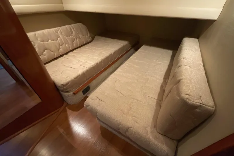 Slide: The Image of 2002 Sea Ray 480 Motor Yacht interior with beige cushioned seating and wooden flooring. - 42