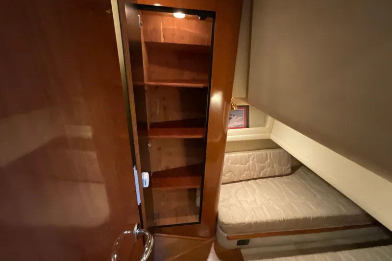 Slide: The Image of 2002 Sea Ray 480 Motor Yacht interior with wooden cabinet and cozy bed. - 43