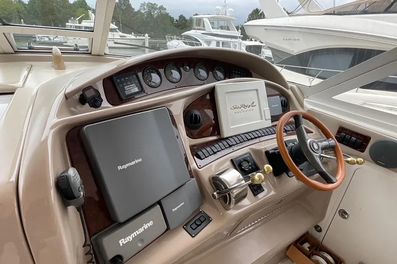Slide: The Image of 2002 Sea Ray 480 Motor Yacht helm with Raymarine navigation equipment and wooden steering wheel. - 8