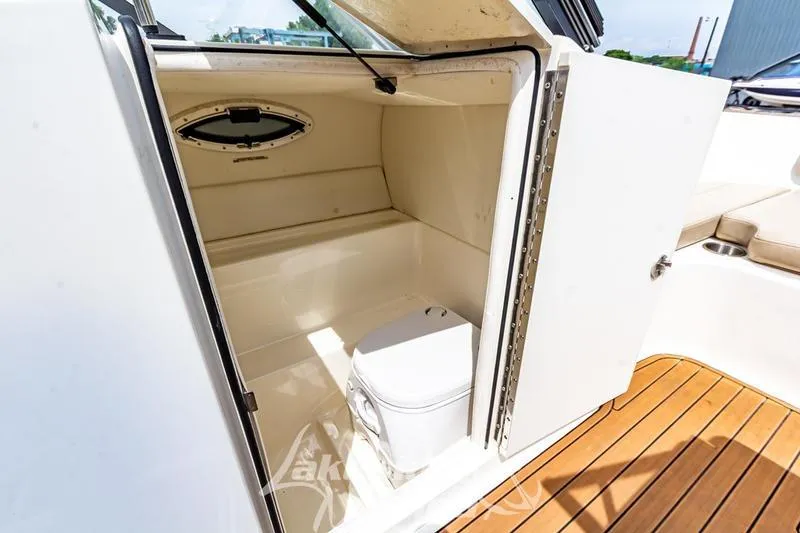 Slide: The Image of 2016 Bayliner VR6 Bowrider I/O boat interior with compact toilet and wooden flooring. - 18