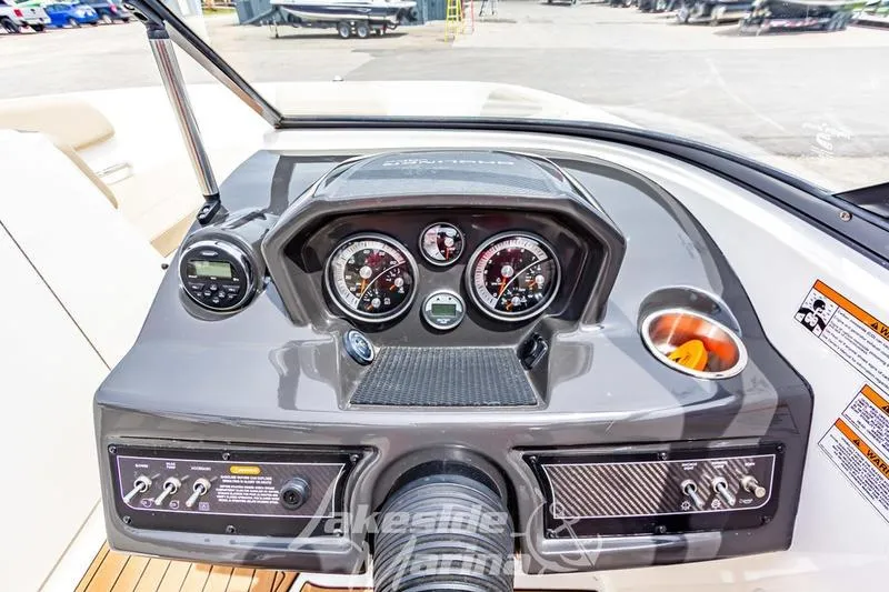 Slide: The Image of 2016 Bayliner VR6 Bowrider I/O dashboard with gauges and controls in a marina setting. - 3