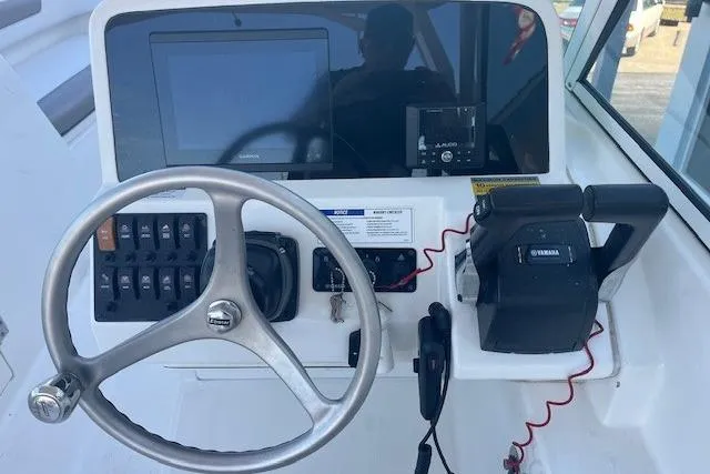 Slide: The Image of 2021 World Cat 230 DC boat dashboard with steering wheel and controls. - 5