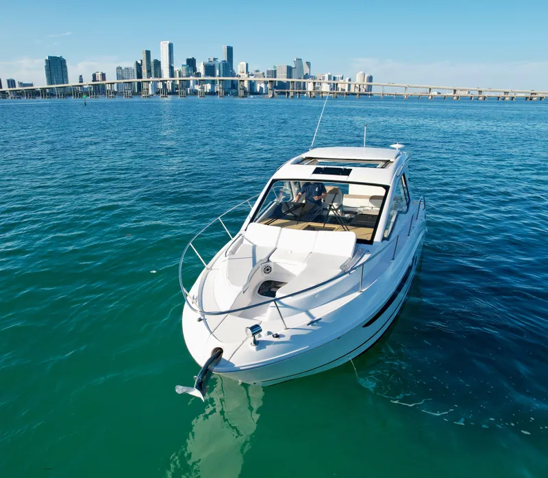 Slide: The Image of 2018 Sea Ray 350 DAC yacht cruising near city skyline on clear blue water. - 10