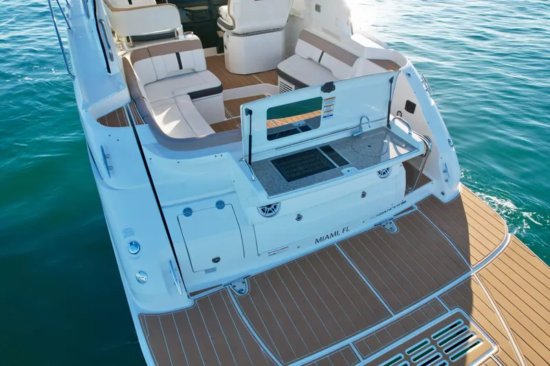 Slide: The Image of 2018 Sea Ray 350 DAC yacht with spacious deck and seating on calm water. - 14