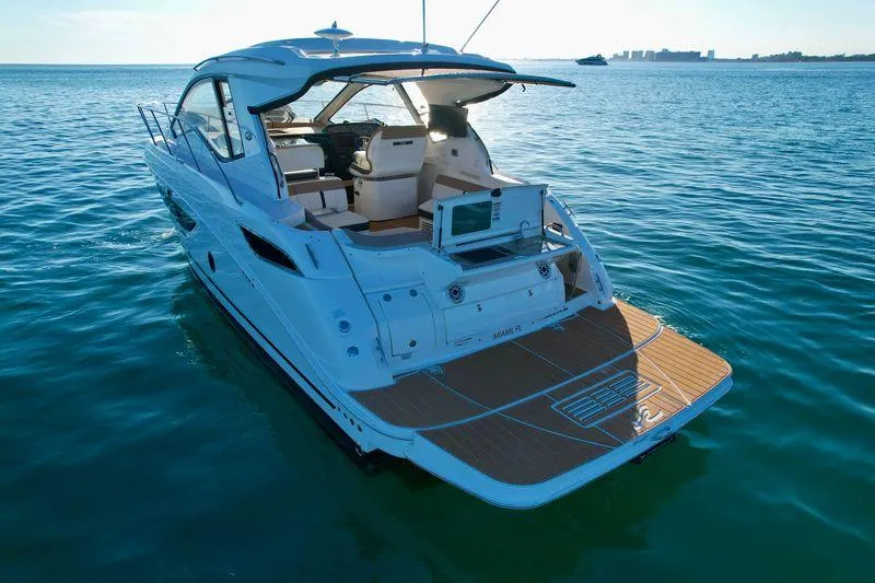 Slide: The Image of 2018 Sea Ray 350 DAC yacht on calm blue water, rear view. - 15