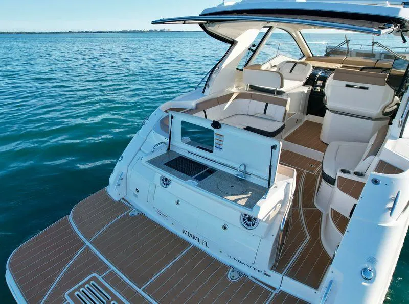 Slide: The Image of 2018 Sea Ray 350 DAC boat with spacious deck and seating on calm water. - 16