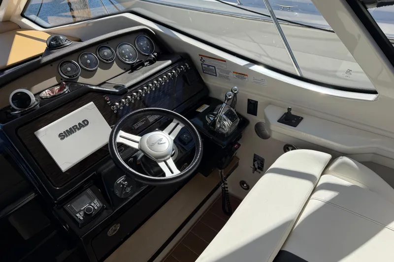 Slide: The Image of 2018 Sea Ray 350 Sundancer helm with Simrad navigation system and luxurious seating. - 19