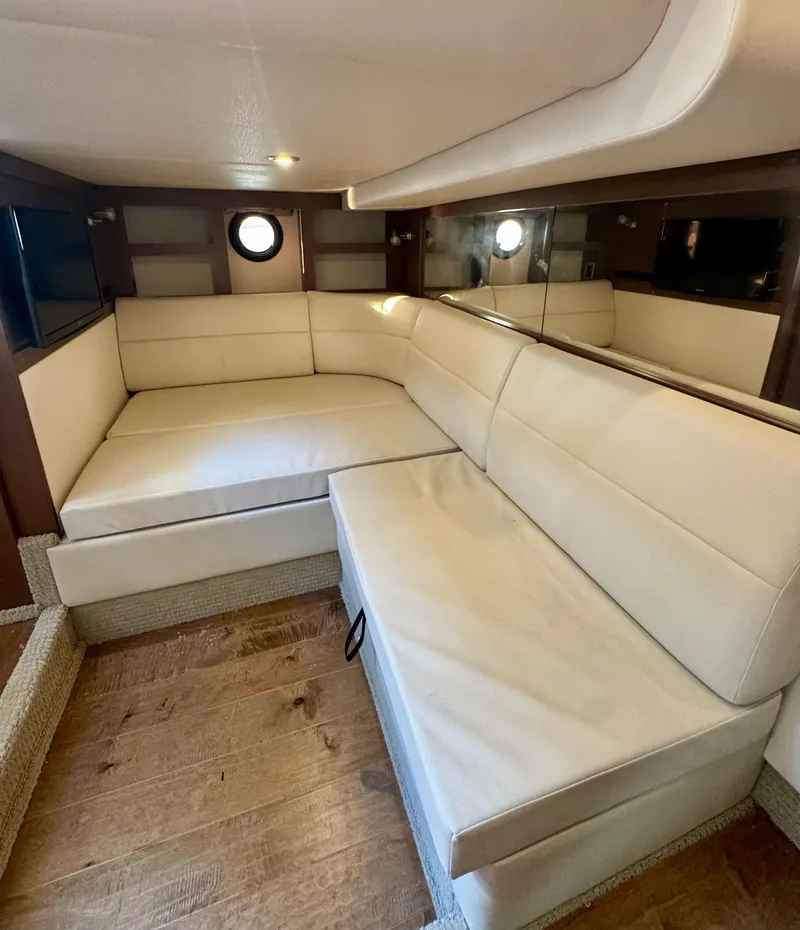 Slide: The Image of 2018 Sea Ray 350 DAC interior with beige leather seating and wood flooring. - 23