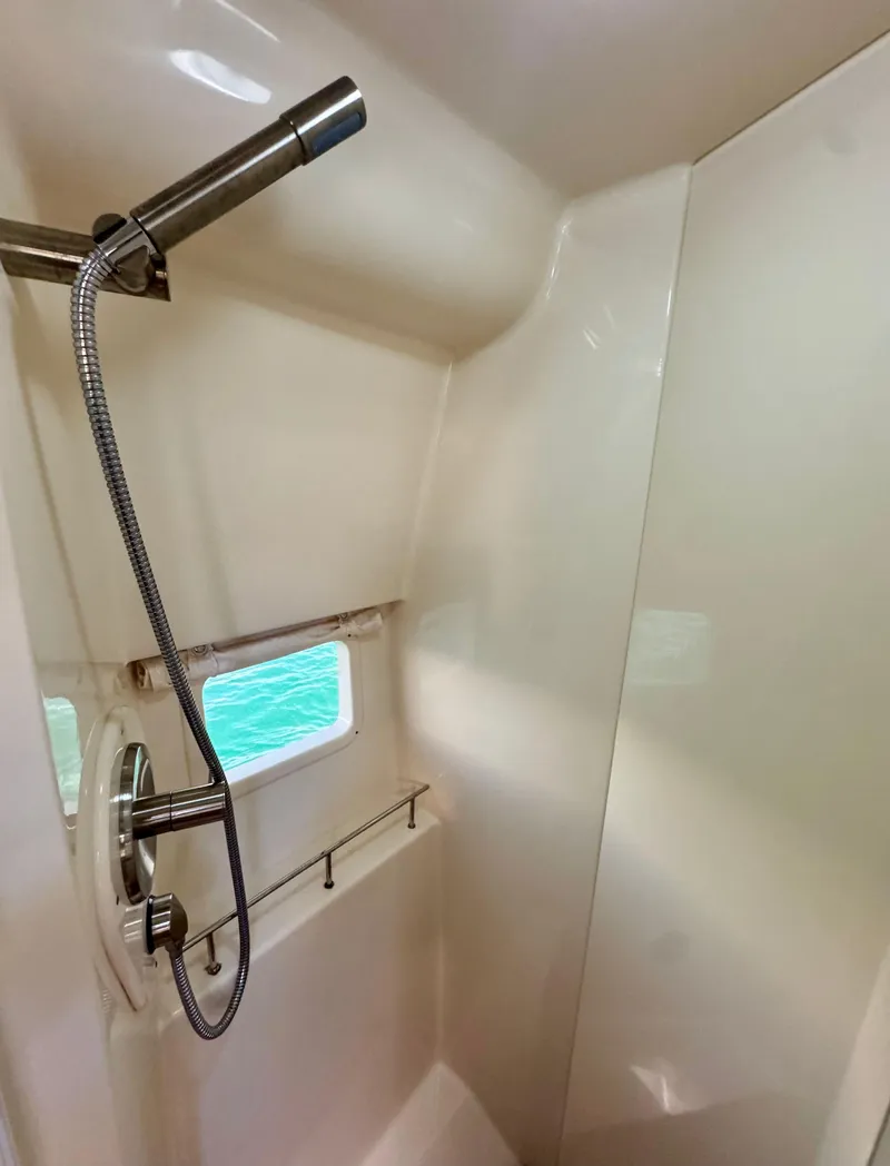 Slide: The Image of 2018 Sea Ray 350 DAC shower area with modern fixtures and window view. - 28